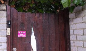 lead Wooden gate with pink sticker. Sticker reads 