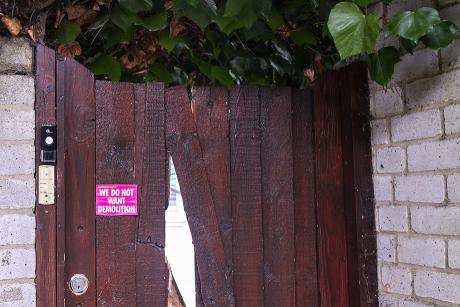 lead Wooden gate with pink sticker. Sticker reads 