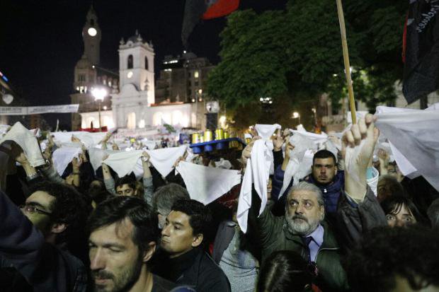 Crowds hold up white headscarves in a protest against the 2x1 law in Argentina