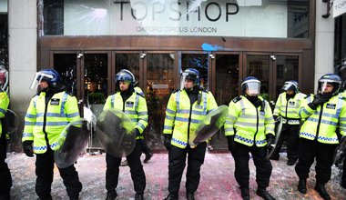 Police guard a paint spattered Top Shop during anti-cuts protest