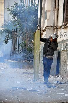 Cairo protester with door and saucepan as shields