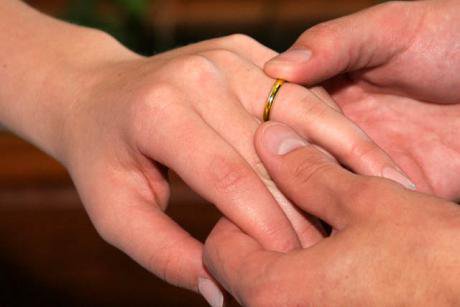 Man putting wedding ring on woman&#39;s finger
