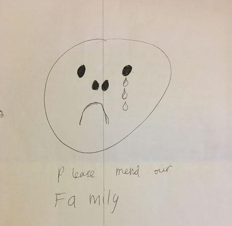 Child's drawing of a sad face with caption, please mend our family.