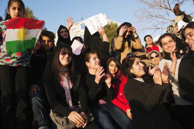 Crowd of women with flag smiling and clapping